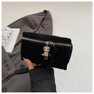 Close-up of black suede crossbody bag featuring a unique silver metal robot charm