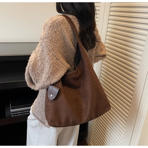 Detail of vintage brown suede tote bag featuring a matching detachable pouch and large strap