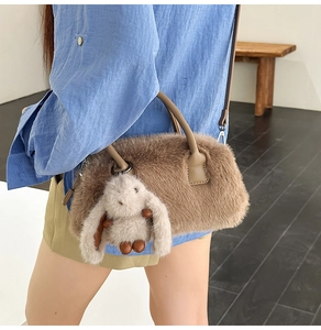 Detailed view of brown faux fur crossbody bag featuring a cute plush bunny charm