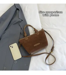 Detailed view of coffee brown suede tote bag with leather handles and size comparison