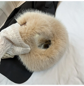 Macro detail of the fluffy beige faux fur texture on the stylish handheld plush bag
