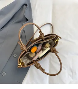 Detail view of brown leather bucket bag interior showcasing ample storage for cosmetics