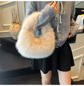 Close-up of fluffy beige faux fur handbag with minimalist U-shaped design for autumn