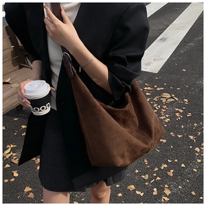Deep brown suede hobo bag shown in an outdoor lifestyle setting for a retro commute style
