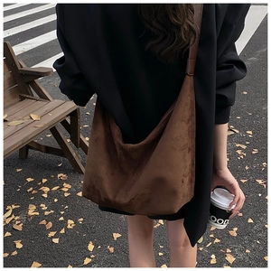 Brown suede hobo bag shown in an outdoor autumn setting with street style aesthetic