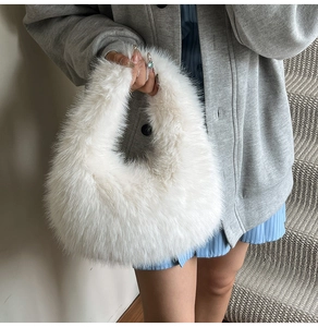 Close-up of white faux fur handbag with soft texture styled with a winter wool coat