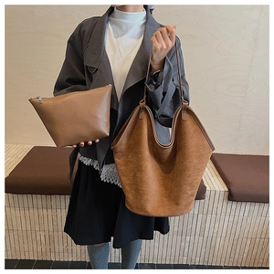 Brown vintage suede tote bag set with matching pouch shown on a model in urban style