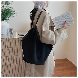 Close-up of a large black tote bag on a model side-shoulder for a minimalist aesthetic