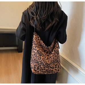 Détail du sac à bandoulière léopard porté avec un manteau en laine noir élégant