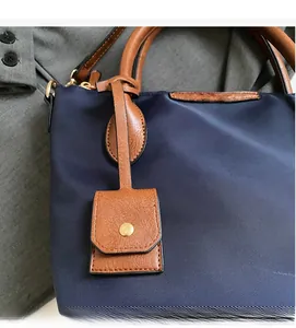 Detailansicht der marineblauen Nylonstruktur und des braunen Lederbesatzes der Tasche