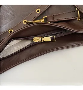 Detail of smooth gold zipper and herringbone fabric lining inside the brown leather tote bag