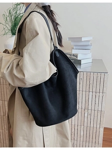 Minimalist black oversized suede tote bag shown on model for elegant urban commute
