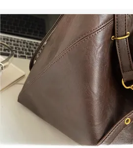 Close-up of dark brown lychee texture leather tote bag with elegant gold buckle