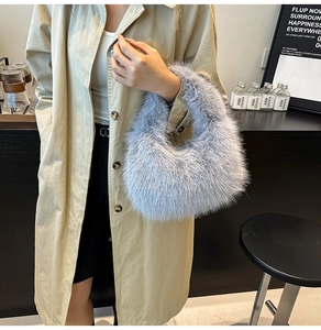 Detail of light blue faux fur handbag featuring a fluffy cloud shape and soft texture