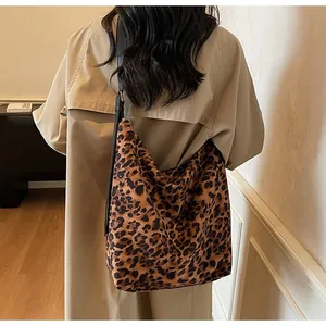 Détail du sac seau léopard avec bandoulière longue sur un trench-coat kaki élégant