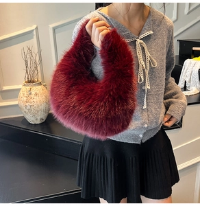 Detail view of burgundy plush crescent bag made of soft faux fur with a cozy winter texture