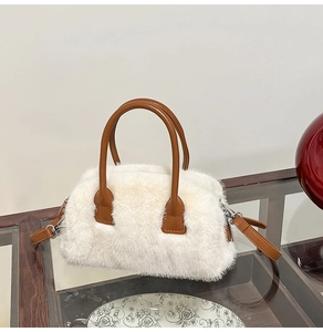 Detailed view of white faux fur handbag with brown leather strap and silver zipper closure