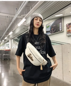 Vue détaillée du sac bandoulière en toile blanche avec écusson Fashion et sangle