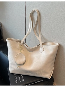Minimalist large off-white tote bag with a round coin purse on a soft grey background