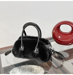 Detail of the soft black faux fur texture and leather handle on the fluffy crossbody handbag