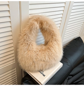 Macro detail of high-density faux fur plush handbag texture in light khaki on a white book