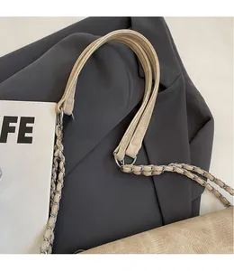 Detailansicht einer beige Kordtasche mit gewebtem silberfarbenem Metallkettenriemen