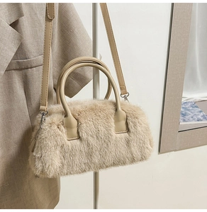 Close-up of fluffy faux fur handbag in beige with leather handle and zipper detail
