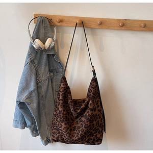 Détail du sac hobo à motif léopard avec une bandoulière noire élégante et une texture douce