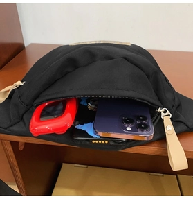 Vue de dessus d'un sac de poitrine en toile noire montrant sa grande capacité interne