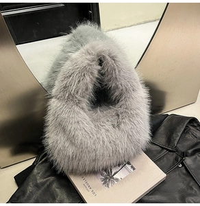 Close-up of plush grey faux fur handbag texture with soft long-hair fibers and premium feel