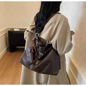 Detailed view of the dark brown matte leather tote bag with stylish lanyards and buckle