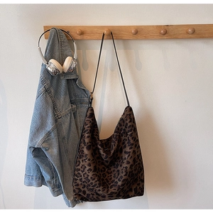 Sac seau à imprimé léopard suspendu à côté d'une veste en jean et d'un casque