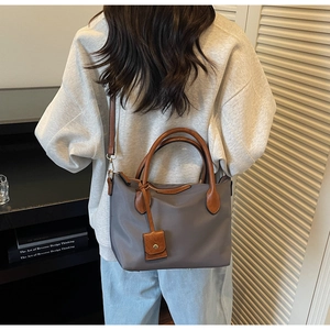 Graue Nylon-Eimertasche am Modell gezeigt für Details zu Größe und Umhängepassform