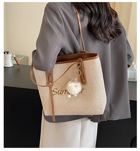 Detail der geflochtenen Strohtasche mit Ledergriffen und Summer-Stickerei