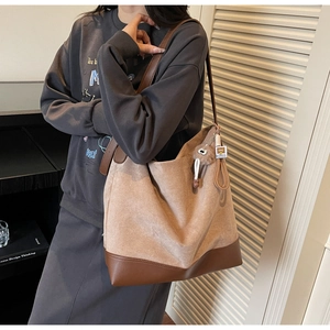 Detail view of khaki suede tote bag with brown leather trim and cute knot charm