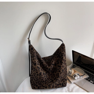 Détail du sac hobo léopard avec bandoulière noire réglable dans un décor quotidien
