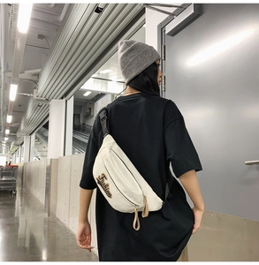 Détail d'un sac de poitrine en toile blanche avec broderie Fashion et sangle réglable