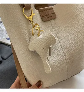 Detail of lychee pattern leather bucket bag with cute detachable elephant pendant accessory
