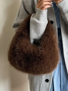Deep brown faux fur crescent tote bag with soft texture shown on a stylish model