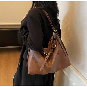 Macro shot of brown faux leather tote with vintage texture and woven rope detail