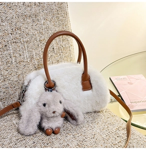 Detail showing white faux fur texture with brown leather handle and cute rabbit charm