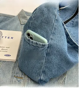 Gros plan d'un sac hobo en jean bleu avec poche latérale pratique et texture rétro chic