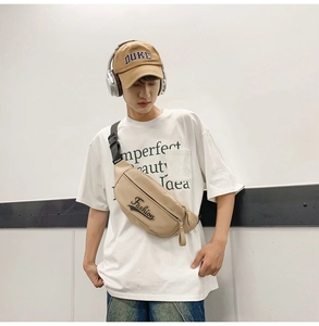 Gros plan détaillé d'un sac à bandoulière en nylon beige avec broderie et sangle noire