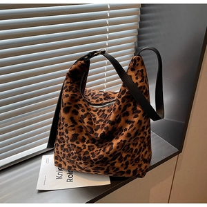 Vue détaillée de la texture imprimé léopard et de la bandoulière en cuir noir du sac