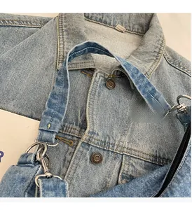 Détail d'un sac à main en jean délavé bleu clair avec poignée solide et anneau en D en métal