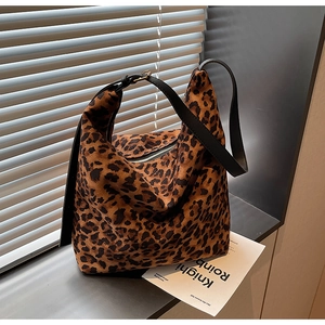 Détail d'un sac seau à motif léopard avec bandoulière en cuir et fermeture éclair argentée