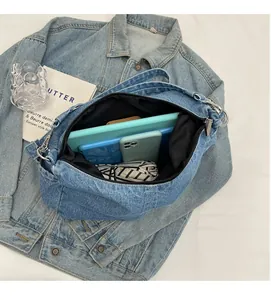 Vue détaillée de l'intérieur du sac en jean bleu montrant le grand espace de rangement