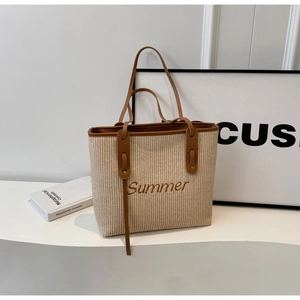 Detail der Summer-Stickerei und braunem Lederbesatz auf gewebter Strohtasche