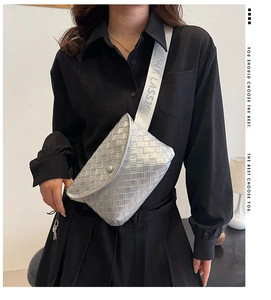 Primer plano detallado de un bolso bandolera tejido plateado con una correa ancha estampada