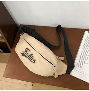 Vue macro détaillée du sac banane en nylon beige avec lettres de sport et zip métallique